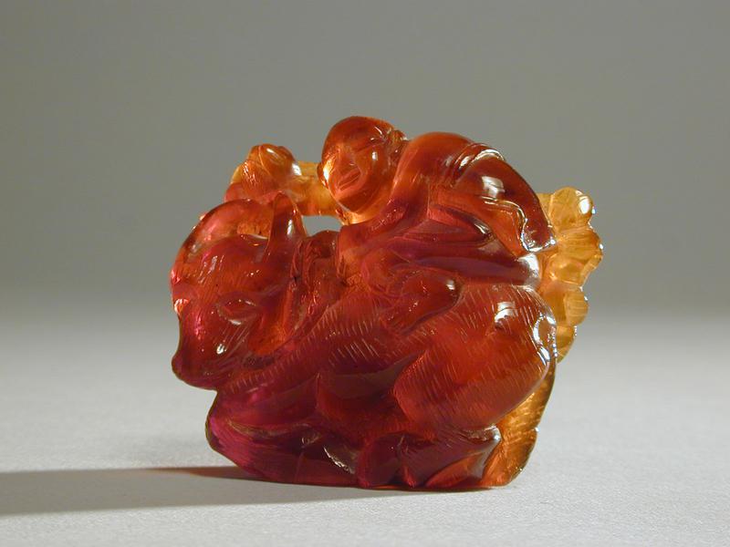 Small Amber Carving of a Boy Seated on a Water Buffalo