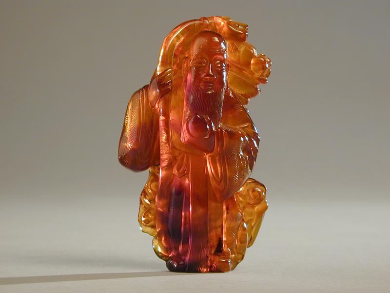 Amber Carving of Shou Lao with a Peach and a Ruyi Sceptre