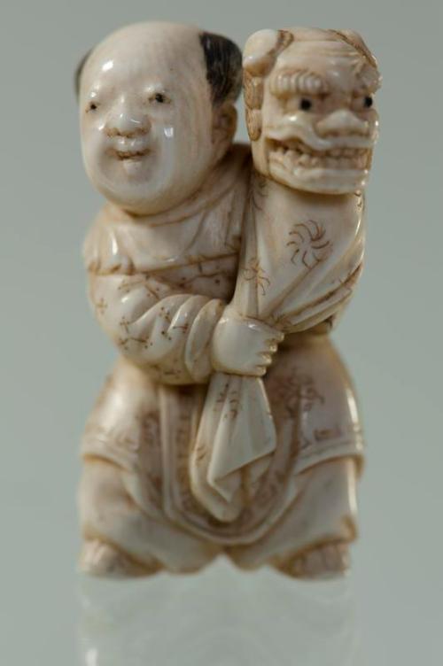 Netsuke of a Boy Holding a Shishi Mask