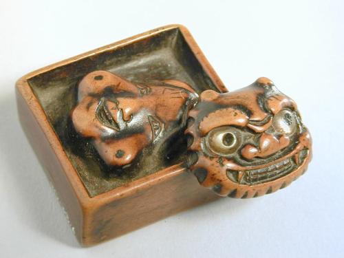 Netsuke of a Box with an Okame Mask and a  Demon Mask